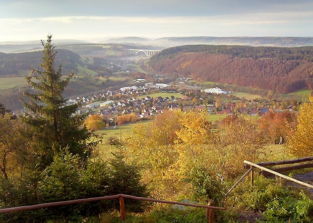 Blick von der Triniushütte in Rauenstein auf den Ort. Die Sonne ist gerade aufgegangen und versucht den Herbstnebel aus dem Thal zu vertreiben.
