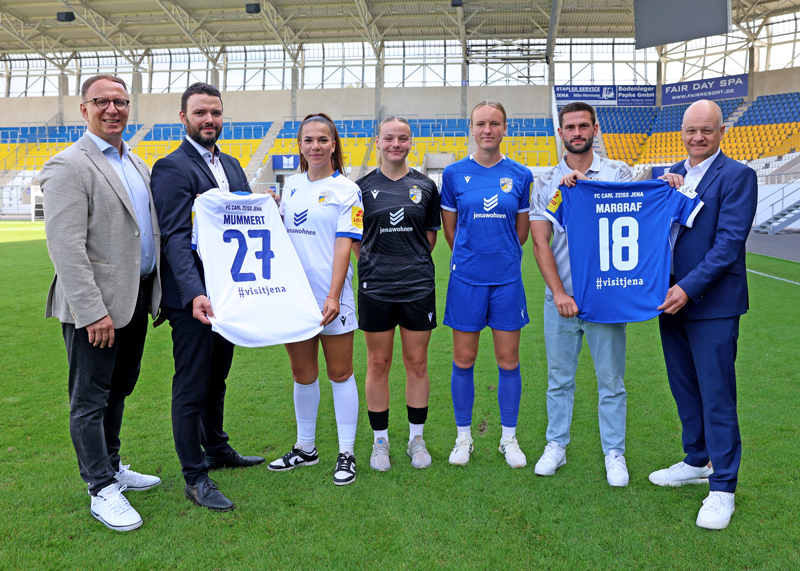Die neuen Trikots präsentiert: v. l. n. r. JenaKultur-Chef Carsten Müller, Sportdezernent Benjamin Koppe, die FCC-Spielerinnen Anika Metzner, Hannah Lehmann und Luca Birkholz, Cheftrainer Florian Kästner sowie jenawohnen-Chef Tobias Wolfrum.
