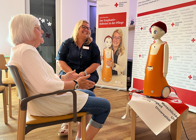Rosies „Mama“ Kristin Döpel-Rabe stellt Bewohnerin Ingrid Kraatz den neuen Pflegeroboter vor.