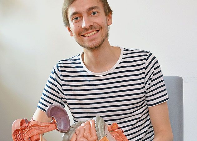 Adrian Magnucki mit den Organen Dünndarm, Magen, Leber und Bauchspeicheldrüse als Plastikmodelle.