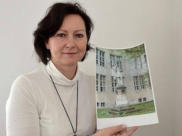 Evelyn Halm zeigt ein Foto des Denkmals, aufgenommen vor der Beschädigung.