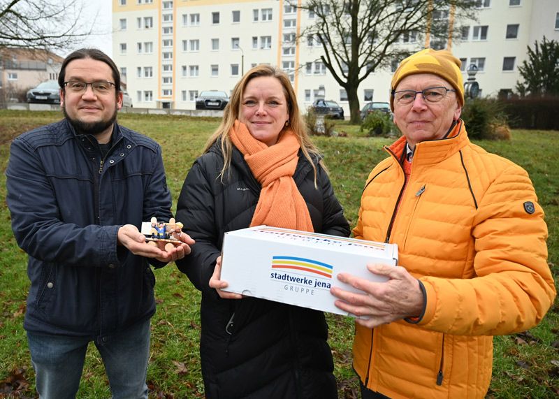 Tina Schnabel (Stadtwerke Jena) überreichte am Freitag eine Kiste mit dem gesammelten Geld und eine symbolische Mini-Bank an Ortsteilbürgermeister Friedrich Wilhelm Gebhardt (r.) und Markus Mess vom Winzerlaer Stadtteilbüro.