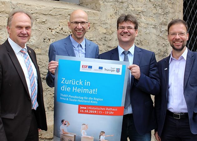 In 2019 fand der erste Pendlertag für Jena und den Saale-Holzland-Kreis noch analog statt: Andreas Heller (Landrat SHK), Wilfried Röpke (Wirtschaftsförderung Jena), Andreas Knuhr (Thüringer Agentur für Fachkräftegewinnung) und Dr. Thomas Nitzsche (Oberbürgermeister Jena) (v.l.n.r.) mit dem Plakat vom letzten Jahr. Dieses Jahr erfolgt die Beratung digital.