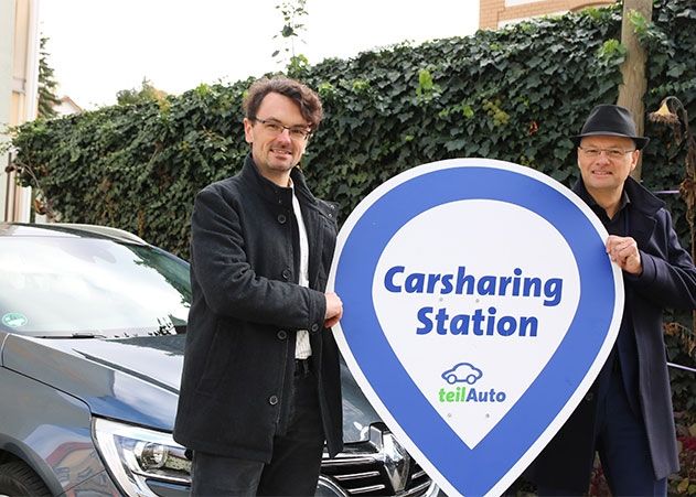 Niklas Wachholtz von teilAuto und Tobias Wolfrum von jenawohnen (v.l.n.r.) an der neuen Station „Am Friedensberg“ in Jena-West.