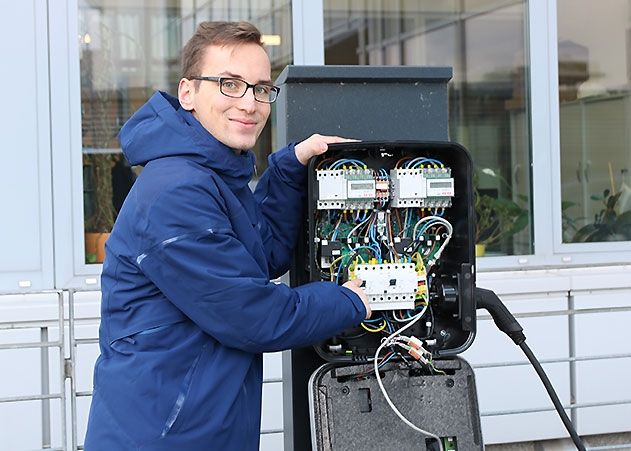 Marcus Wöckel von den Stadtwerke Jena Netzen erprobte das dynamische Lademanagement und zeigt, wie eine Ladesäule des Systems von innen aussieht.