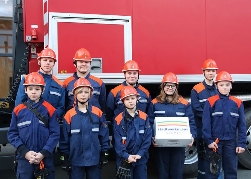 Kinder und Jugendliche der Jugendfeuerwehr Winzerla freuen sich über die Spende der Stadtwerke Mitarbeiter.