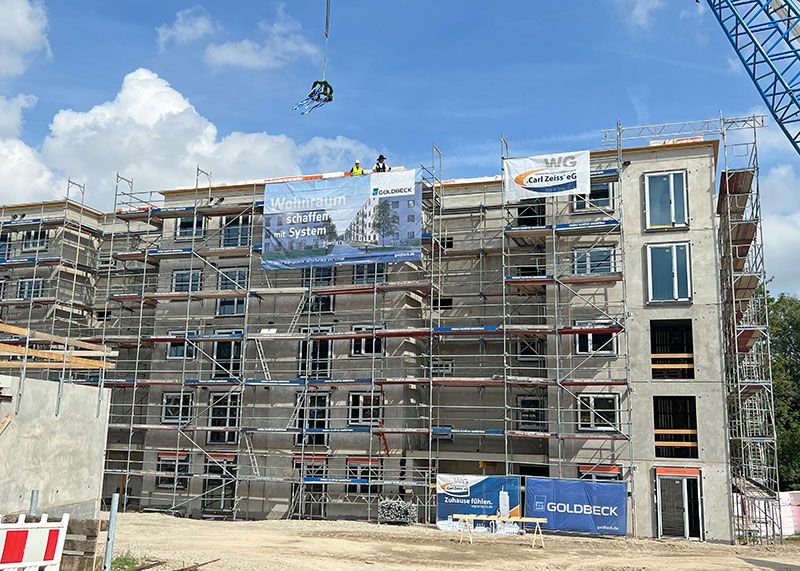 Am Donnerstagmittag schwebte die Richtkrone hoch über den künftigen Sozialwohnungen.