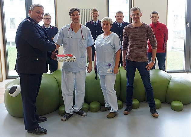 Mario Hoffmann vom Feuerwehrverein Langenwolschendorf e.V. übergibt die Spende an den UKJ-Kinderkardiologen Daniel Vilser.