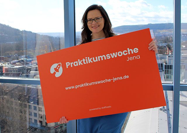 Projektleiterin Daniela Drilltzsch von JenaWirtschaft präsentiert die Werbetafel zur Praktikumswoche 2022. Alle Jenaer Unternehmen sind eingeladen, sich und ihre Angebote für den Fachkräftenachwuchs zur Praktikumswoche in den Osterferien vorzustellen.