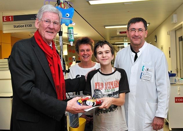 Lobedas Ortsteilbürgermeister Volker Blumentritt (l.) überreicht dem 15-jährigen Marcus (2.v.r.) weihnachtliche Geschenke. Mit dabei auch die Mutter des Jugendlichen und Prof. Dr. James F. Beck, Direktor der Jenaer Kinderklinik (r.).