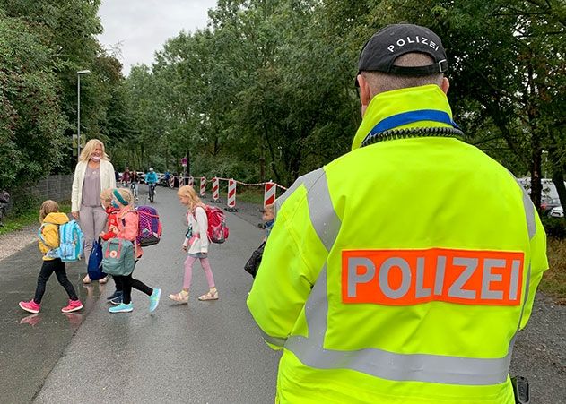 Schulleiterin Kerstin Braschel, unterstützt von Jan Alberts, Kobb für Jena-Ost lenkt ihre Schüler über die Straße am Camsdorfer Ufer.