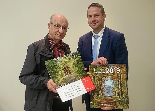 Klaus Enkelmann, Vorsitzender des Unifok Jena e.V. (links) und Michael Rabich, Vorstandsvorsitzender der Sparkasse Jena-Saale-Holzland mit dem neuen Sparkassenkalender 2019.