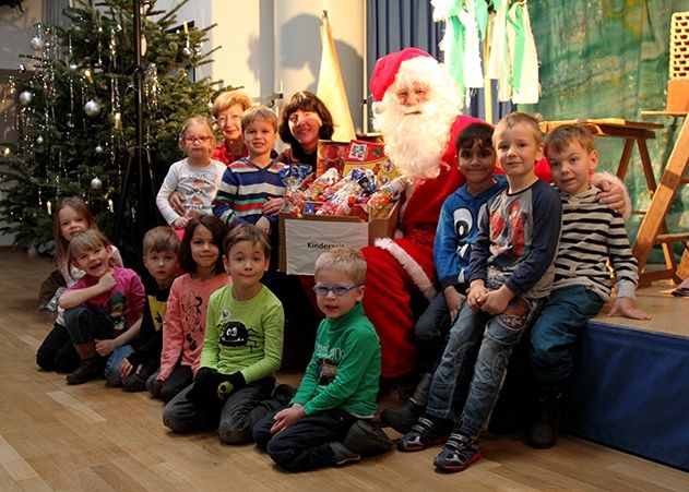 Zur traditionellen Kinderweihnachtsfeier verteilte der Weihnachtsmann (alias Volker Blumentritt) Kisten vollgepackt mit allem, was das Kinderherz begehrt. Im Bild die Kinder der AWO-Kita „Kinderzeit“ mit ihrer Erzieherin Evelyn Duda und Elisabeth Wackernagel (l.) vom Ortsteilrat.