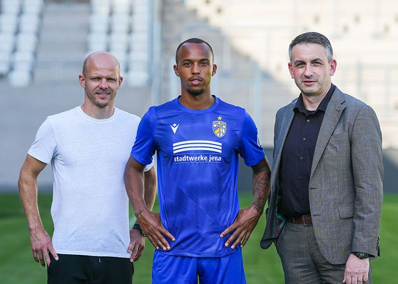 v.l.n.r. Sportdirektor Tobias Werner, FCC-Neuzugang Jonathan Muiomo und Stadtwerke-Geschäftsführer Gunar Schmidt,  präsentieren das neue Trikot für die kommende Saison.