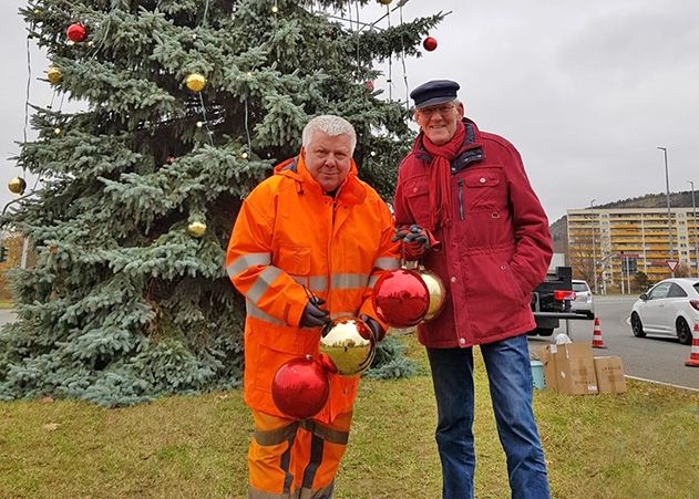 Peter Peisker vom Kommunalservice Jena und Lobedas Ortsteilbürgermeister Volker Blumentritt (r.) schmücken den Baum.