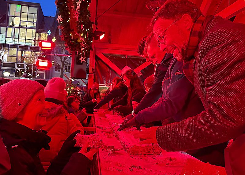 Oberbürgermeister Thomas Nitzsche (r.) hat mit dem Anschnitt des traditionellen Riesenstollens den Weihnachtsmarkt in Jena eröffnet.