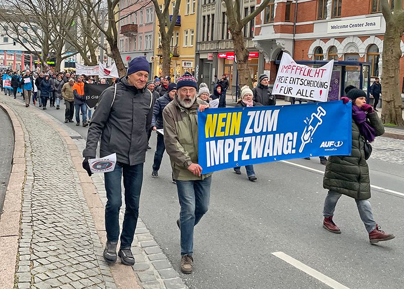 Etwa 100 Impfgegner artikulieren ihren Unmut mit Bannern und Plakaten.