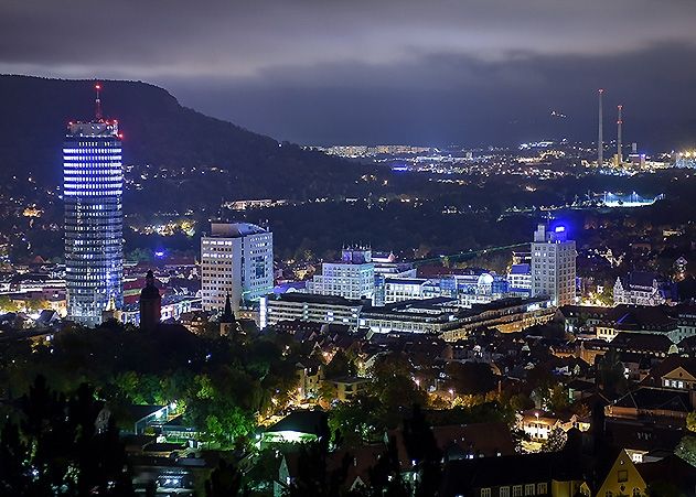 Die Stadt Jena ist bei Nacht hell erleuchtet.