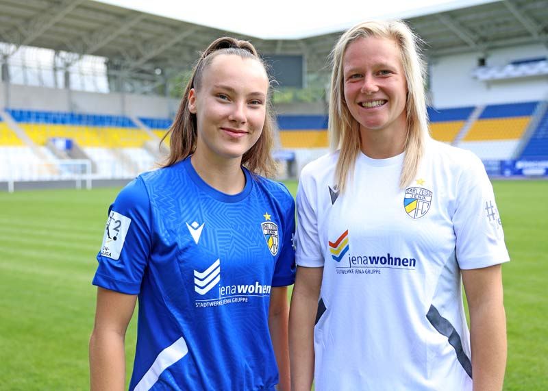 Felicia Sträßer und Annalena Breitenbach (r.) präsentieren die neuen FCC-Trikot.