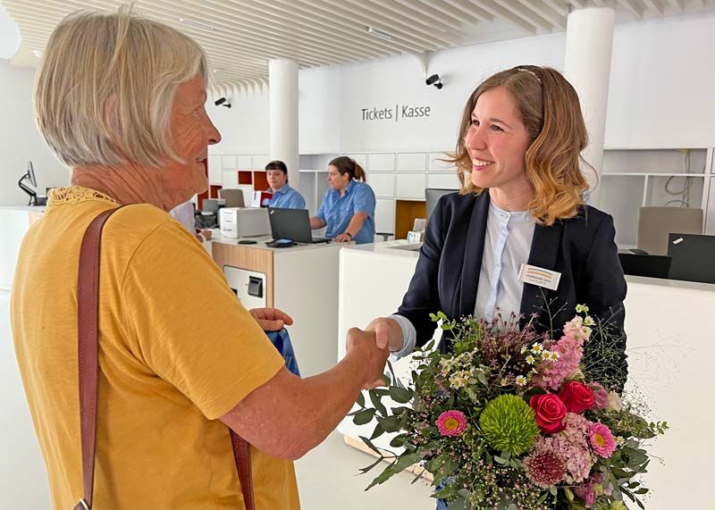 Antje Fritzsche (links) war mit ihrem Anliegen, ein 9-Euro-Ticket zu kaufen, die erste Kundin im neuen Stadtwerke-Kundencenter. Jeanette Peters, Leiterin des neuen Kundencenters übereichte ihr zur Begrüßung einen Blumenstrauß.
