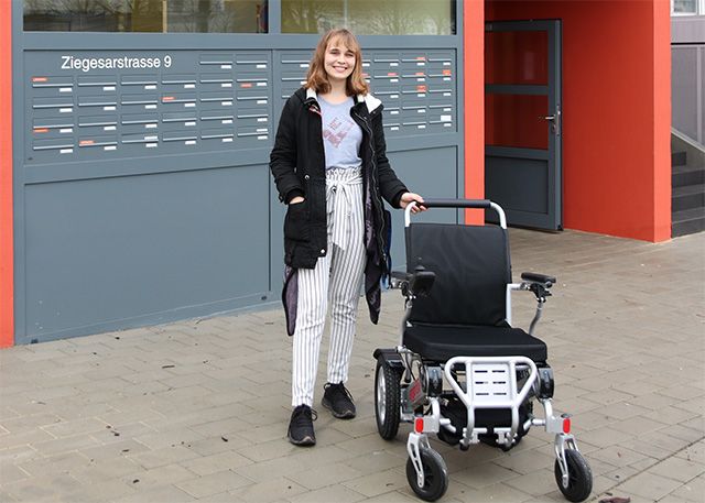Leah Jasmin Schöße, Quartiersmanagerin im Smarten Quartier, mit dem E-Rollstuhl des Thüringer Sanitäts- und Gesundheitshauses Carqueville.