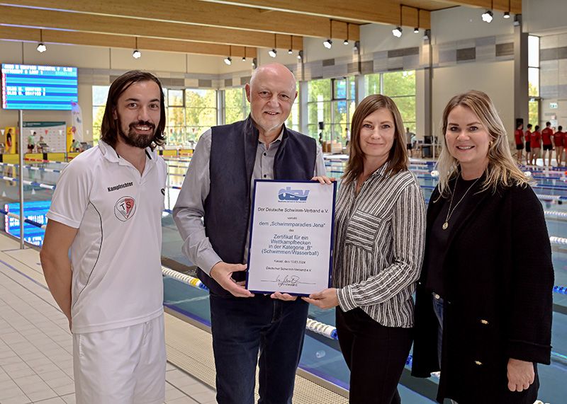 Stefan Engelhardt vom Thüringer Schwimmverband übergibt das Zertifikat gemeinsam mit Wolfgang Hein vom Deutschen Schwimmverband (2.v.l.) an Franziska Greiner (Jenaer Bäder) und Bäderchefin Susan Zetzmann (r.).