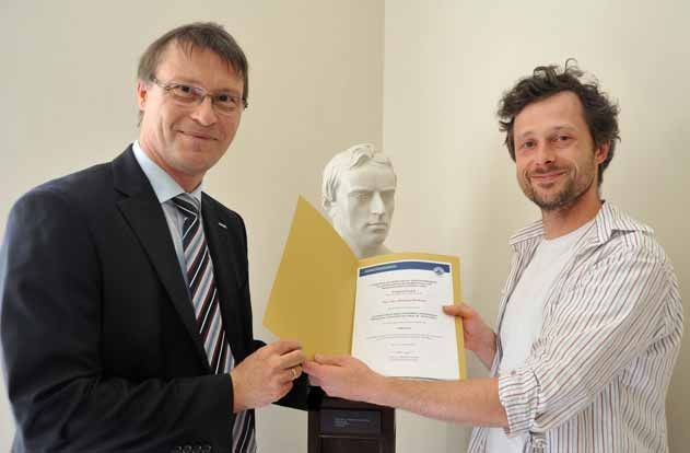 Dr. Michael Markert (r.) erhält den Fördermittelbescheid aus den Händen von Prorektor Prof. Dr. Thorsten Heinzel.