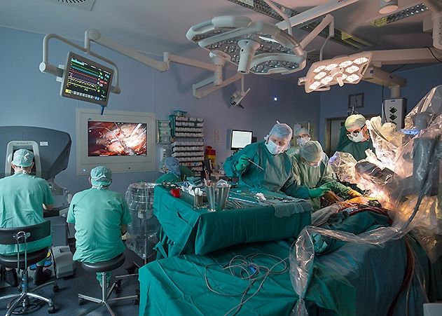 Mit Unterstützung des DaVinci-Operationsroboters behandeln Herzchirurgen am Universitätsklinikum Jena eine erkrankte Mitralklappe im Herzen. Der Operateur (links im Bild) sitzt an einer Konsole, über die er die Instrumente steuert, die an den Roboterarmen befestigt sind.