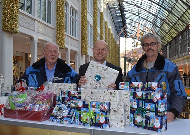 Centermanager Michael Holz (m.) übergibt die Geschenke an Tafel-Vorsitzenden Willfried Schramm (l.) und Mitarbeiter Hartmut Kampf.