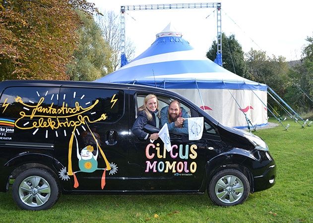 Tina Schnabel (Leiterin Unternehmenskommunikation Stadtwerke Jena) und Friedemann Ziepert (Zirkusdirektor Circus MoMoLo) weihen gemeinsam das E-Auto ein.