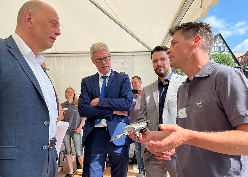 Thüringens Wirtschaftsminister Wolfgang Tiefensee, Dr. Thomas Knoll (Referatsleiter Digitales und Kreativwirtschaft im Thüringer Ministerium), Benjamin Koppe ( Jenas Dezernent für Digitalisierung) im Gespräch mit Prof. Dr. Christian Thiel vom Deutschen Zentrum für Luft und Raumfahrt.