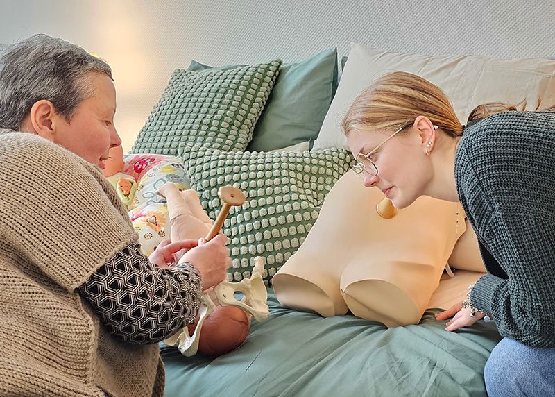 Kristin Rammel erklärt Marie Charlotte Scholz die Arbeit einer Hebamme mit dem Hörrohr.