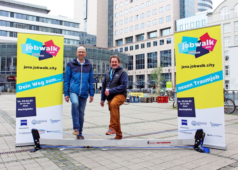 Freuen sich auf viele Besucher:innen zum Jobwalk Jena 2023: Wilfried Röpke (JenaWirtschaft, l.) und Organisator Peter Böttger (r.) an der Slackline für die Jobwalk-Werbetour.