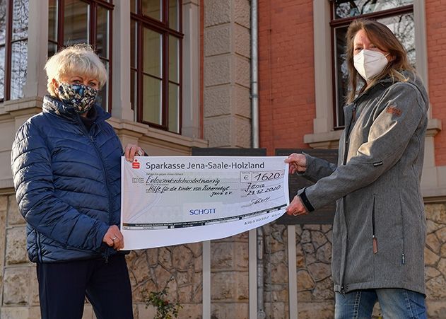 Constanze Gebauer (re.) vom Verein „Hilfe für die Kinder aus Tschernobyl in Jena“ e.V. übernimmt den symbolischen Spendenschenk von Ute Haubold von der Unternehmenskommunikation SCHOTT.