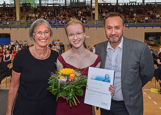 Lea Jabschinsky (Mitte) bekommt den Otto-Schott-Ehrenpreis 2021 durch Armin Vogel (rechts), Leiter der Jenaer Floatfertigung und Christine Neuwirth (links), Direktorin des Jenaer Otto-Schott-Gymnasiums, am 09.07.2021 im Sportkomplex Jena-Lobeda.