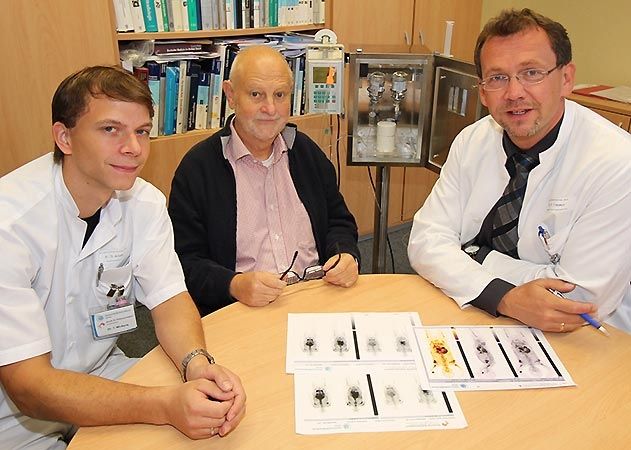 UKJ-Nuklearmediziner Dr. Thomas Winkens (links) und PD Dr. Martin Freesmeyer (rechts), Chefarzt der Klinik für Nuklearmedizin am UKJ, erläutern dem ersten Patienten die Wirkungsweise der neuartigen PSMA-Therapie bei Prostatakrebs.