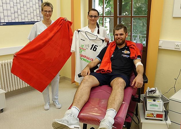 Science City Jena-Spieler Julius Wolf sichert sich mit seiner Blutspende am UKJ das erste Handtuch der Aktion zum Handtuchtag.