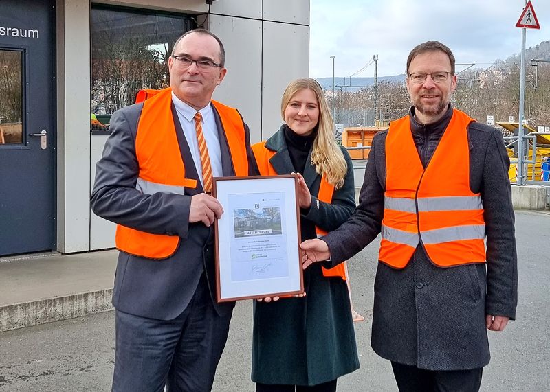 Andrea Kostrowski, Referentin Kreislaufwirtschaft DUH, überreicht KSJ-Werkleiter Uwe Feige (l.) und Jenas OB Thomas Nitzsche die Urkunde.