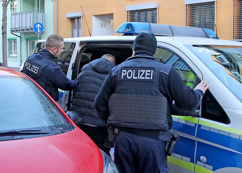 Der Verdächtige wird festgenommen: Beamte der Bundespolizei führen ihn aus seinem Wohnhaus in den Gefangenentransporter.